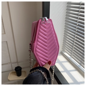 Detailed view of pink coffin-shaped crossbody bag with V-quilted faux leather finish