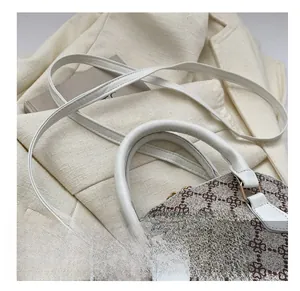 Close-up of flexible white shoulder strap and gold hardware on vintage patterned shell bag