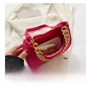 Detail view showing large capacity of magenta leather bag with gold chain and accessories