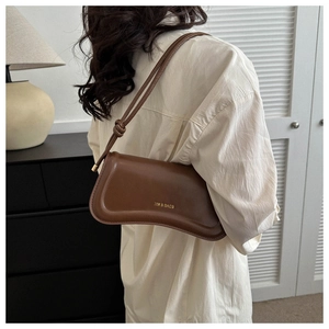 Detail einer braunen Umhängetasche mit XM & BAGS Logo und elegantem Design
