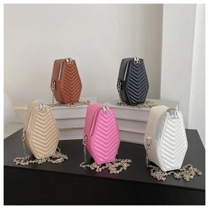 Quilted coffin-shaped chain crossbody bags in five colors displayed on books