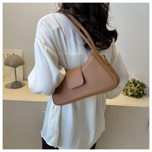 Chic brown faux leather baguette bag worn by model in a minimalist home setting