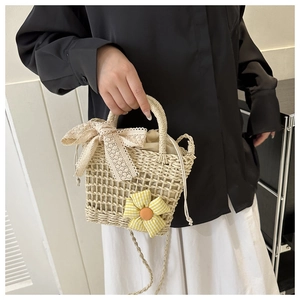 Detail der Strohtasche zum Umhängen mit Spitzenschleife und Blumendekor mit Kordelzug