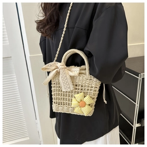 Detailansicht der Stroh-Eimer-Tasche mit Spitzenschleife und kariertem Blumenakzent