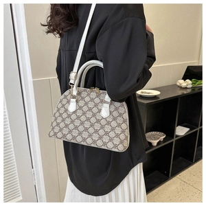 Detailed close-up of a white and brown monogram shell crossbody bag worn by a model