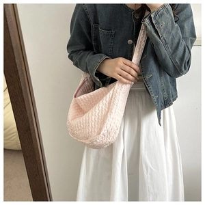 Pink pleated texture crossbody bag shown on model with casual autumn commute styling