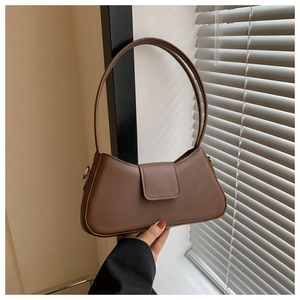 Detailed view of dark brown PU leather handbag featuring a secure magnetic flap closure