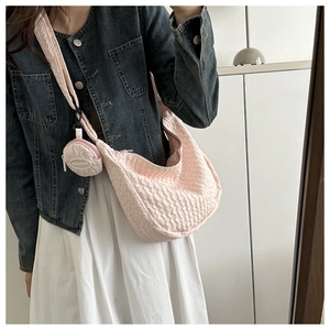 Detailed view of pink pleated crescent bag with detachable round coin purse on shoulder strap