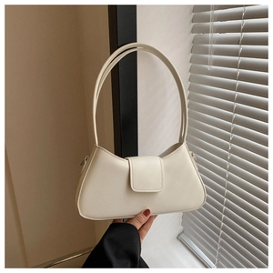 Close-up of minimalist cream white faux leather shoulder bag with magnetic flap closure