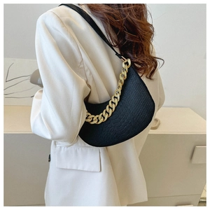 Detail of black faux crocodile embossed crescent bag with chunky gold chain strap