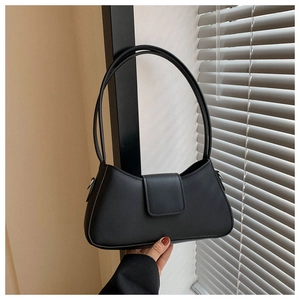 Close-up of minimalist black faux leather shoulder bag with smooth matte finish and slim handles