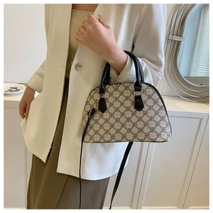 Detail of shell-shaped crossbody bag with monogram pattern and gold-tone hardware