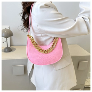 Detail of neon pink crescent armpit bag with crocodile embossing and gold chain