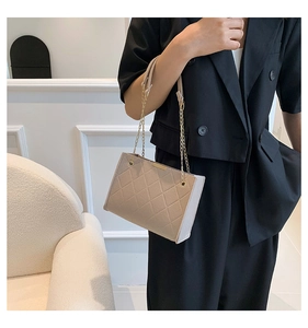 Detail view of the beige quilted crossbody bag with metal chain strap and sleek metal trim