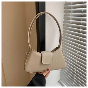 Detail view of stylish beige PU leather underarm bag with long strap and magnetic flap