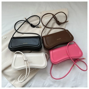 Detail minimalistischer Schultertaschen mit gebogenem Boden und XM & BAGS Goldlogo