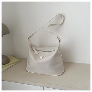 Detailansicht der minimalistischen beigen Hobo-Tasche aus Leder mit breitem Schultergurt