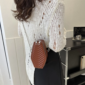 Brown quilted coffin-shaped crossbody bag with silver chain strap shown on model back