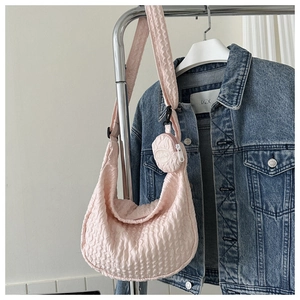 Pink quilted hobo bag with detachable coin purse displayed on metal hanger