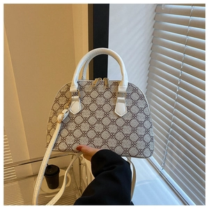 Detail of white shell handbag with clover pattern and elegant gold zippers in natural light