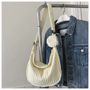 Detail of pale yellow pleated crescent bag with detachable round coin purse on a hanger