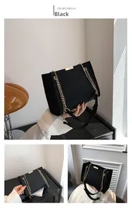 Detail view of black quilted felt crossbody bag with golden chain and metallic buckle