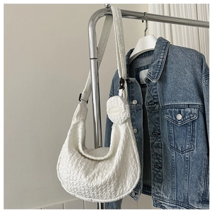 Detail of white pleated hobo bag with small round coin purse and FASHION embroidery