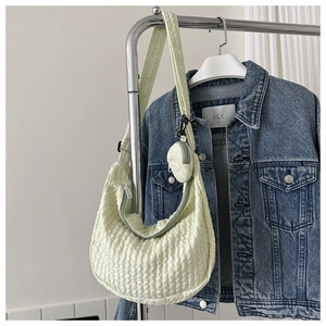 Detail of light green bubble texture crescent bag with detachable round coin purse on hanger