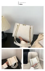 Detailed view of white quilted tweed crossbody bag with golden chain and square lock