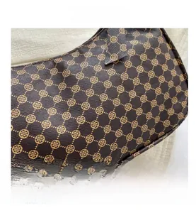 Close-up of brown monogram clover pattern on textured cross-grain faux leather bag