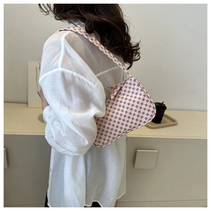 Detail of pink shoulder bag with geometric prints worn with a white shirt