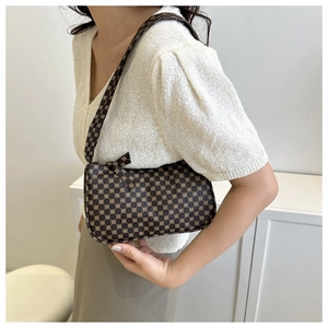 Detailed macro view of brown shoulder bag with golden geometric pattern and smooth zipper