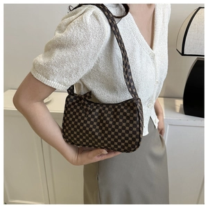 Lifestyle shot of a vintage coffee brown crescent shoulder bag with retro pattern print