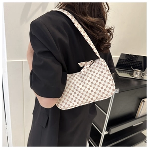 Detail of white baguette bag with red geometric pattern and elegant bow shoulder strap