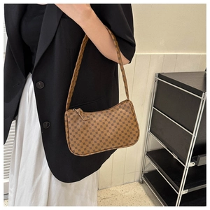 Close-up of brown geometric pattern shoulder bag styled with a minimalist outfit