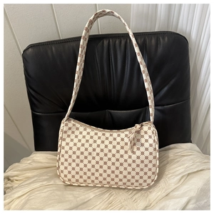 Detailed view of cream and brown retro monogram pattern on a semi-circle shoulder bag