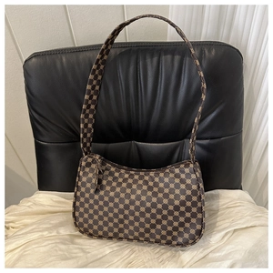 Detail of vintage brown printed baguette shoulder bag with geometric pattern and top zipper