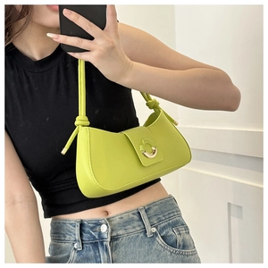Detailed side view of avocado green half-moon underarm bag with gold metal lock