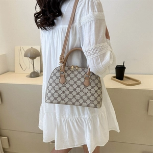 Chic shell-shaped crossbody bag with vintage clover pattern and brown leather handles