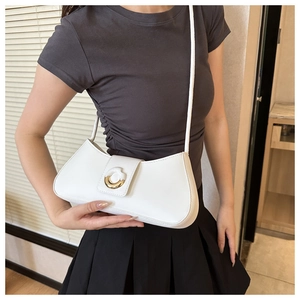 Minimalist white leather half-moon bag with gold ring buckle worn as underarm style