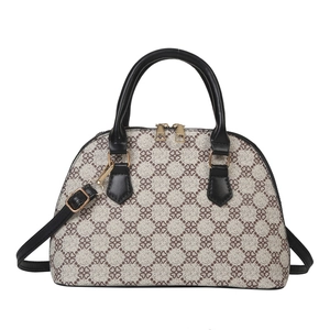 Classic shell-shaped handbag with monogram pattern and black leather handles in front view