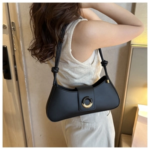 Detail of black baguette shoulder bag with gold ring buckle and knotted strap design
