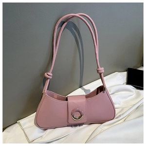 Detailed macro view of a pink baguette bag with golden metal buckle and sleek leather texture