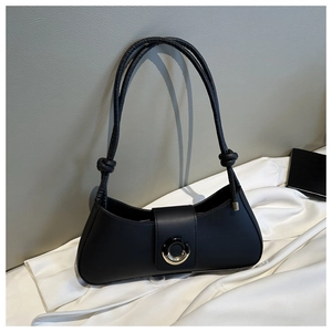 Close-up of black underarm bag with unique metal ring buckle and knotted shoulder strap