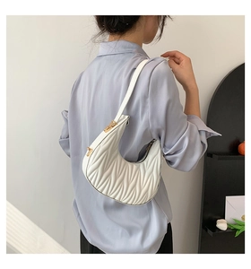 Back view of a model wearing a white pleated crescent shoulder bag for daily commute