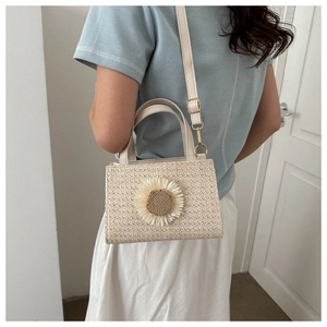 Detail of woven straw bag with sunflower decoration and adjustable shoulder strap