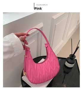 Close-up of pink matelasse crescent hobo bag with gold padlock hardware and pleated texture