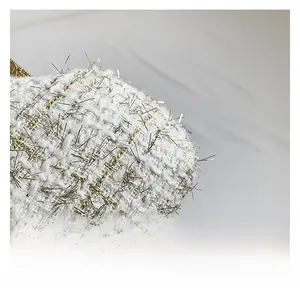 Macro shot of white tweed fabric texture with interwoven gold and silver metallic threads