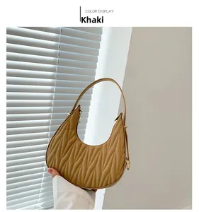 Detail view of khaki crescent bag featuring pleated texture and zipper closure