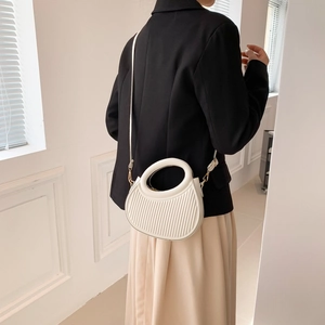 Sac bandoulière beige semi-circulaire minimaliste avec gaufrage vertical et boucle dorée